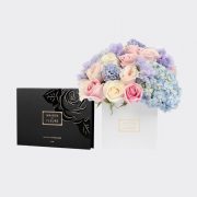 Gift set of mixed fresh flowers in sweet pastel shades in a white 15 cm square box, with a small box of chocolates.