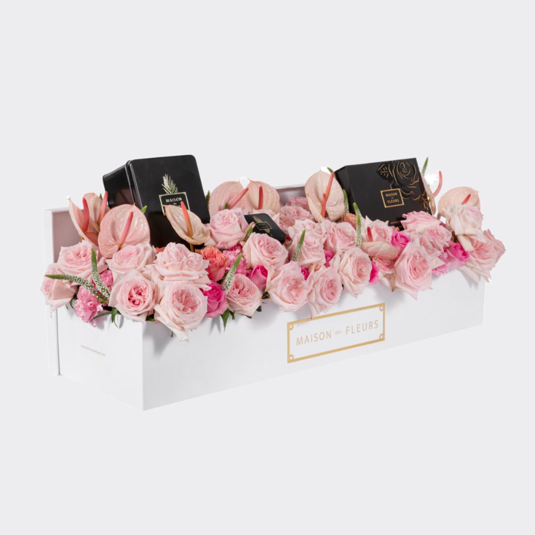 An arrangement of mixed pink fresh flowers coupled with a box of premium dates and chocolates.